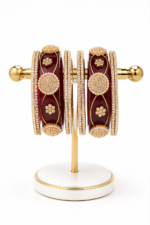 Maroon Embellished Bangle Set
Beautiful dark maroon bangles with golden detailing and sparkling stonework. - Image 2